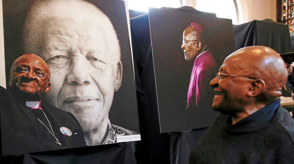 epa04342120 South African Nobel Peace laureate Archbishop Emeritus Desmond Tutu looks at photographs by South African photographer Sumaya Hisham during an exhibtion depicting his public and private life at the St. George's Cathedral in Cape Town, South Africa, 05 August 2014. Muslim photographer Sumaya Hisham documented the Christian Archbishop as a charity project exposing some never seen before moments in the life of the famous South African. The retired Anglican Archbishop is an iconic figure....