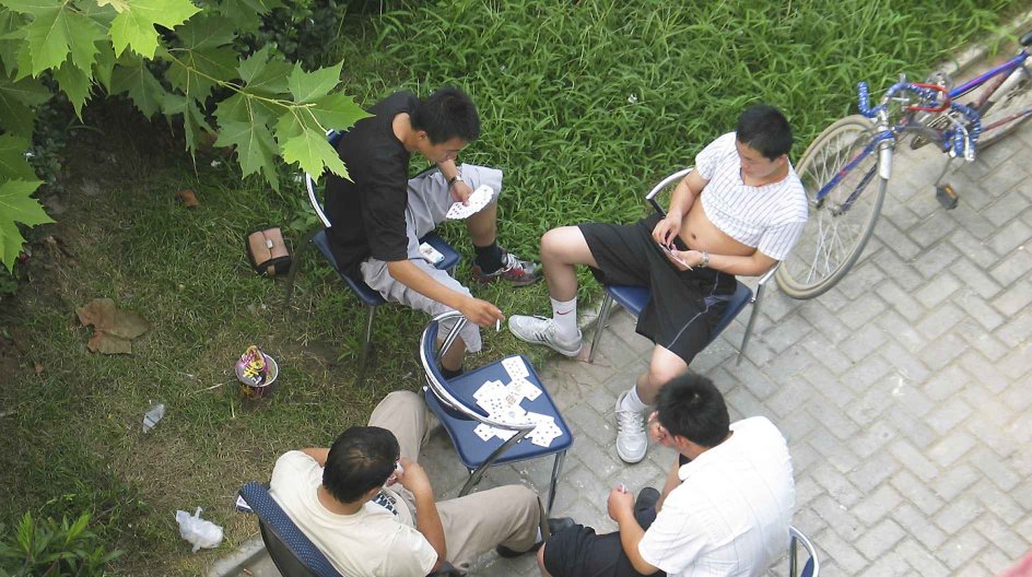 20060807 BEIJING, CHINA. A Group of Chinese policemen in plain clothes guard the home of a prominent dissident Hu Jia in front of his apartment building in Beijing in August 2006. The policemen guard Hu's door 24 hours a day preventing him from going out. Photo taken secrectly by Hu Jia himself from his balcony.(Photo by Hu Jia)  