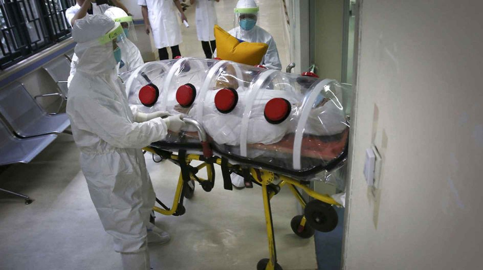 Medical personnel (back) take pictures with their mobile phones as health workers in protection suits transport a mock patient into a quarantine ward during a drill to demonstrate the procedures of handling Ebola victims, at a hospital in Guangzhou, Guangdong province October 16, 2014. Picture taken October 16, 2014. REUTERS/Stringer (CHINA - Tags: HEALTH) CHINA OUT.NO COMMERCIAL OR EDITORIAL SALES IN CHINA