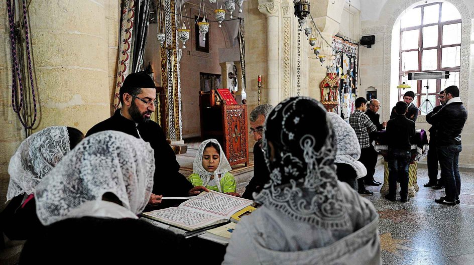 TO GO WITH AFP STORY BY PHILIPPE ALFROY Assyrian Christians pray in a church in Mardin, southeastern Turkey, on November 18, 2014. The Christian Assyrian community in Turkey, which now numbers no more than a several thousand, has been hit by wave after wave of immigration even since the foundation the modern Turkish state in 1923 out of the ruins of the multi-ethnic Ottoman Empire. But hope has not been lost that a future presence can be continued and memory of the past retained, with some expec....