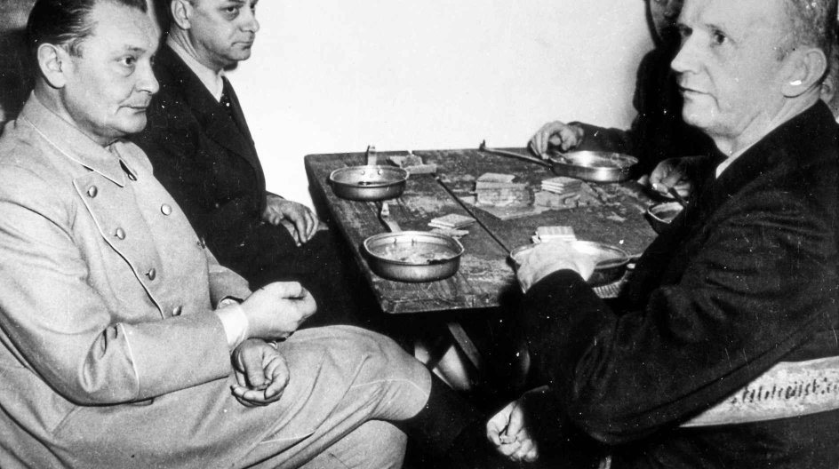 War criminals of the Nazi regime (left to right) Hermann Göring, Alfred Rosenberg, Baldur von Schirach and Karl Dönitz sit at a wooden table with metal plates and pieces of bread during the Nuremberg Trials in 1946. Photo: Yevgeny Khaldei