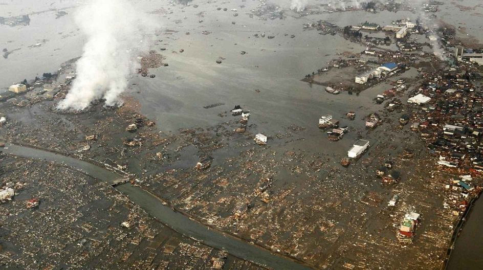 TO GO WITH Japan-disaster-accident-nuclear-anniversary, ADVANCER by Hiroshi Hiyama (FILES) This file photo taken on March 12, 2011 shows an aerial view of tsunami damage and flooding in Natori, Miyagi prefecture a day after the country was devastated by an earthquake and tsunami that milled some 19, 000 people. March 11, 2013 marks the second anniversary of the 9.0 magnitude earthquake that sent huge a wall of water into the coast of Tohoku, splintering whole communities and ruining acres of pri....
