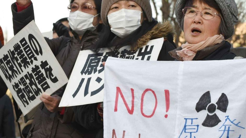 People shout slogans and display banners during a rally denouncing nuclear plants and criticizing the Tokyo Electric Power Company (TEPCO) operating body, in front of the prime minister's official residence in Tokyo on March 11, 2015. Japan marked the fourth anniversary on March 11 of a quake-tsunami disaster that swept away thousands of people and sparked a nuclear crisis, a tragedy that has left visible scars on the landscape and continues to wreak misery for many. AFP PHOTO / TORU YAMANAKA