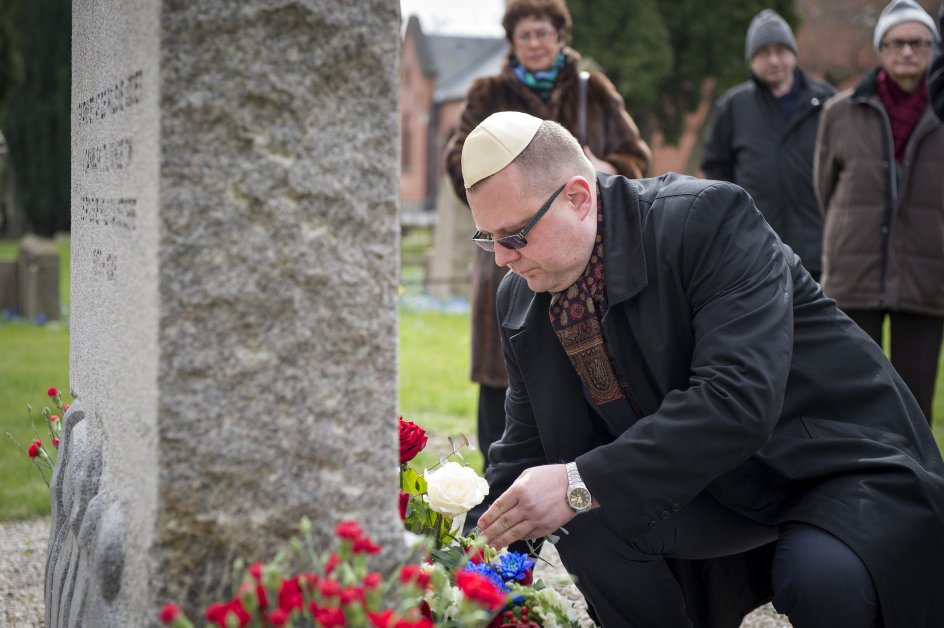 En repræsentant fra Polens ambassade i Danmark ligger blomster ved mindesmærket for de polske holocaustofre.