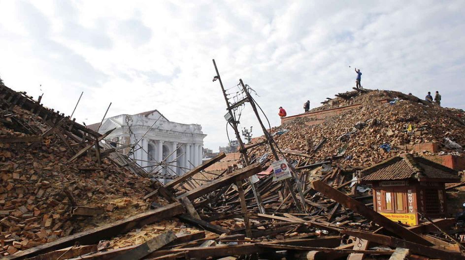 epa04722319 Local people gather at the top of large mound where once stood a temple to view the scene of devastation in Kathmandu, Nepal, 27 April 2015 following the massive earthquake that hit the country on 25 April 2015. The death toll has passed the 3, 200 mark with many more thousands expected EPA/ABIR ABDULLAH