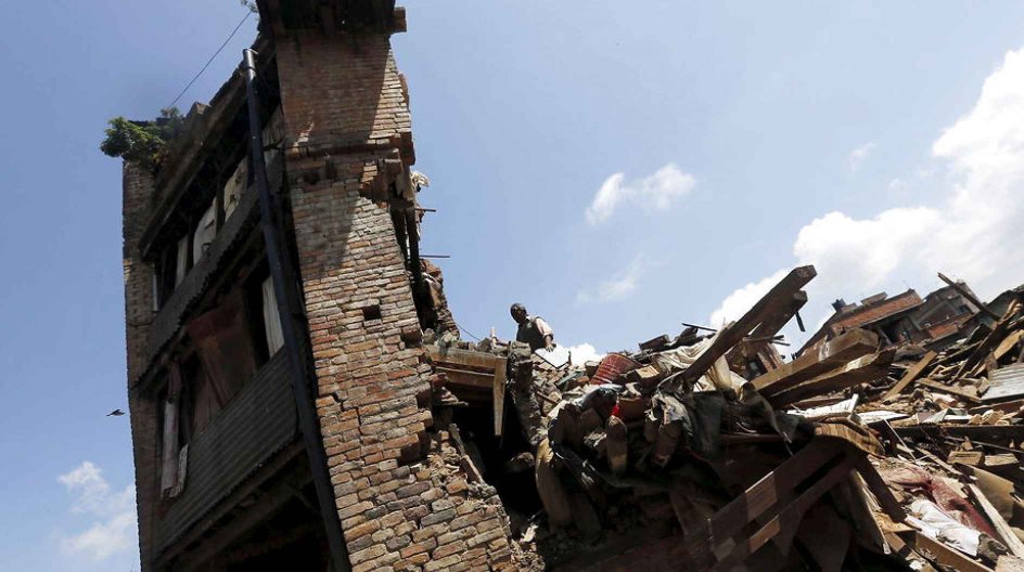 A man looks into his damaged house to recover belongings following Saturday's earthquake in Bhaktapur, Nepal April 27, 2015. REUTERS/Adnan Abidi