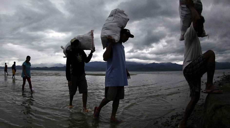 epa04692633 Filipinos carry sacks of relief goods during distribution on the island of San Ildefonso, Casiguran township, Aurora province, Philippines, 05 April 2015. The Philippines weather bureau downgraded Typhoon Maysak to a tropical storm as it continues to weaken while moving closer toward the country's eastern coast. The weather bureau says Maysak's strength is no longer capable of generating storm surges, but warned that it could generate surface waves of up to eight metres near the cent....