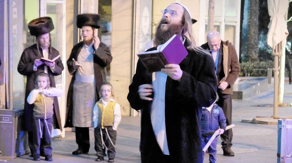 En gruppe ultraortodokse jøder demonstrerer mod en café i Jerusalem, der holder åbent på sabbatten. -