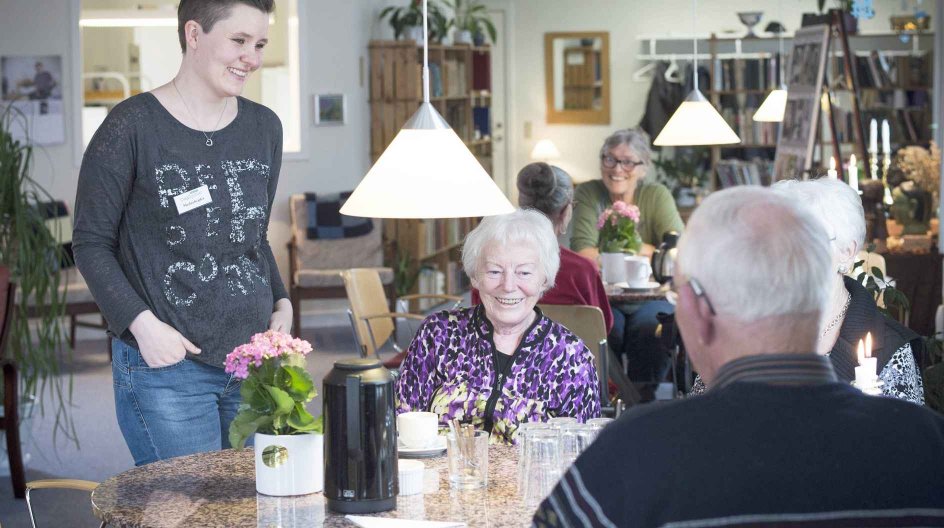 Rikke Bak Johansen (tv.) og Anna Lauridsen hygger sig med et par af de øvrige gæster i Sognets Dagligstue.