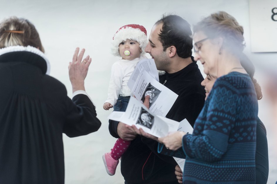 En armensk baby med nissehue og babyens far deltager også i gudstjenesten. 