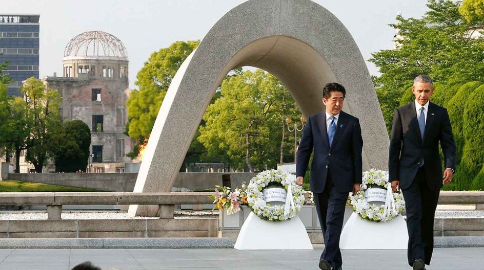 US President Barack Obama (R) walks with Japanese Prime Minister Shinzo Abe after laying wreaths in front of a cenotaph to offer a prayer for victims of the atomic bombing in 1945, at Hiroshima Peace Memorial Park in Hiroshima on May 27, 2016. Obama on May 27 paid moving tribute to victims of the world's first nuclear attack. / AFP PHOTO / POOL / KIMIMASA MAYAMA