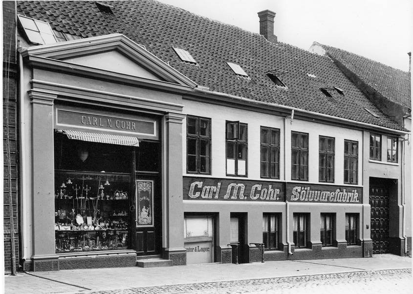 "Er der nogen virksomhed, der har gjort sølv til eje for alle, er det Cohrs fabrikker,” sagde den museumsinspektør på Nationalmuseet Hans Lassen i 1961 i forbindelse med åbningen af en udstilling om guld og sølv herhjemme. Her ses et billede af Cohrs butik og fabrik i Danmarksgade i Fredericia midt i sølvtøjets storhedstid omkring århundredeskiftet. – Foto: