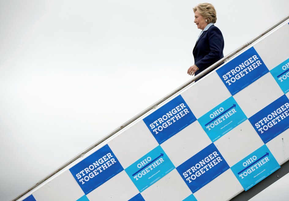 Hillary Clinton ankommer til Tolodos lufthavn, hvor hendes slogan ”Stronger Together” (Stærkere sammen) dominerer flytrappen. Det er et slogan, hun er stolt af, for det er fremkommet i en idéproces. ”Det fungerer, også fordi jeg faktisk mener det,” siger hun. –