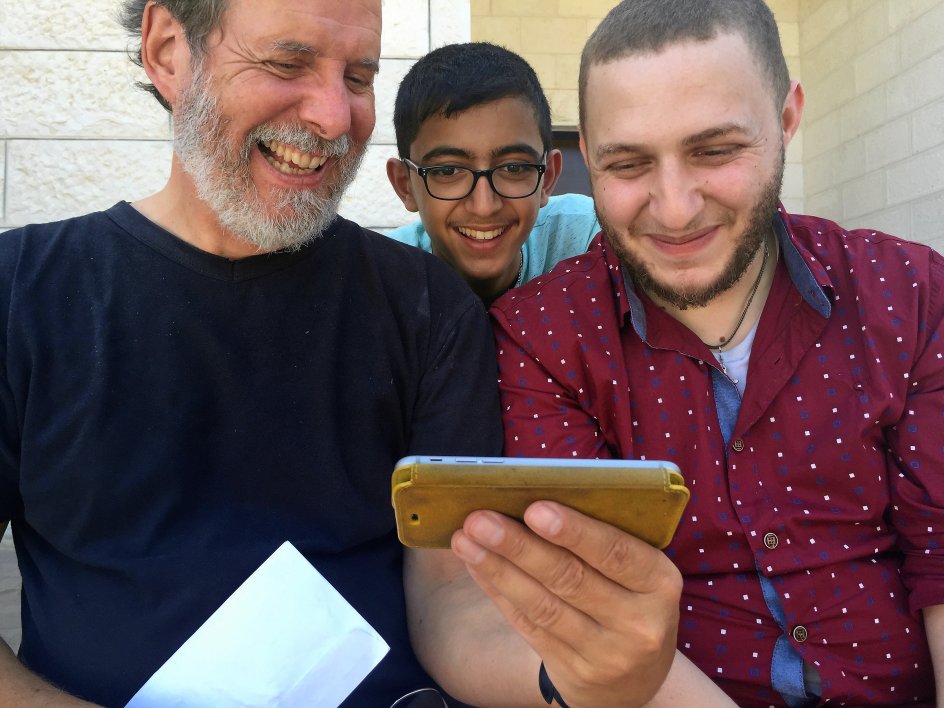 Henrik Goldschmidt har let til latter. Her viser han et koncertklip fra sit Middle East Peace Orchestra for de to palæstinensiske musikere. I midten ses den 16-årige Fadi Bascha, der senere sammenlignede Henrik Goldschmidt med en engel. –