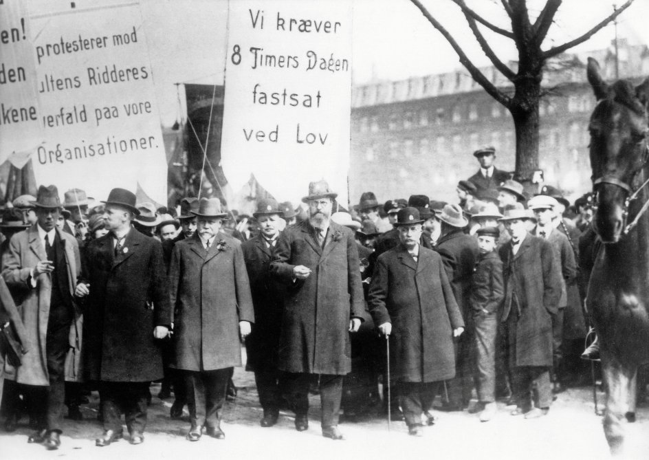 Demonstration på Grønttorvet i København. Året var 1916, og forrest i midten gik socialdemokraten Thorvald Stauning, der senere skulle blive Danmarks længst siddende statsminister. Dengang ville partiet i sit principprogram ”afskaffe det kapitalistiske privateje”.