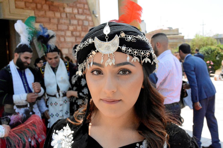 Reema Khammo har boet i Sydney, Australien, siden hendes forældre emigrerede i 1990’erne. Hun er iført den traditionelle folkedragt for assyriske kristne. Hun er i Irak sammen med en større gruppe kristne, der er taget fra Australien til Erbil sammen.