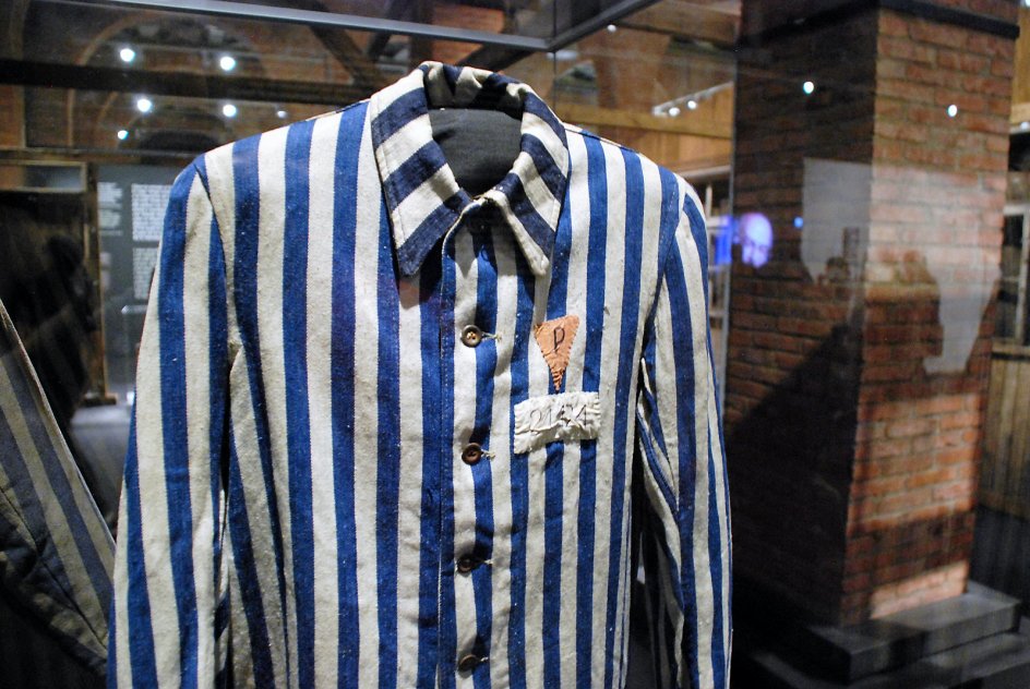 Genstande som sko, barberkoste, ødelagte briller og denne blå-hvid stribede fangedragter skal give museumsgæster et indtryk af livet og især døden i Auschwitz. –