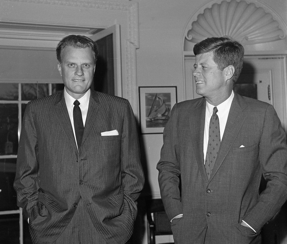 Billy Graham har bedt med amerikanske præsidenter, siden Dwight D. Eisenhower sad i Det Hvide Hus. Her ses han i december 1961 sammen med Eisenhowers afløser, John F. Kennedy. – 