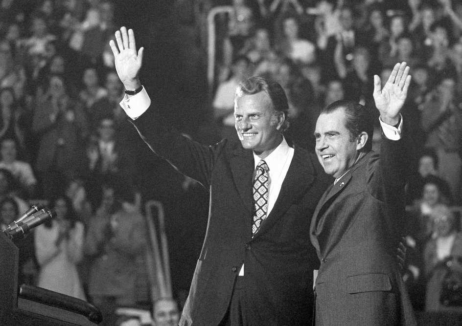 Richard Nixon, som måtte trække sig som præsident som følge af Watergate-skandalen, var en af Billy Grahams personlige venner. Her ses den daværende præsident og prædikanten vinke til de 12.5000 fremmødte ved en hyldest for Graham i dennes hjemby Charlotte i 1971. – 