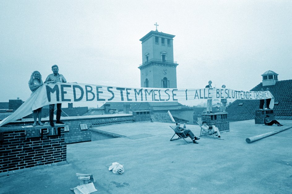 Studenterdemonstration på taget ved Københavns Universitet med Vor Frue Kirke i baggrunden.