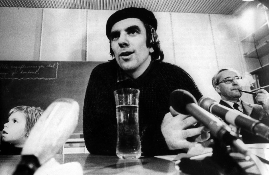 Tre-årige Hosea Dutschke yderst til venstre sammen med sin far, Rudi Dutschke, under et pressemøde på Aarhus Universitet efter familien Dutschkes ankomst til Danmark i 1971. Rudi Dutschke skulle blandt andet holde forelæsninger om proletariatets diktatur. Til højre ses professor Johannes Sløk. –