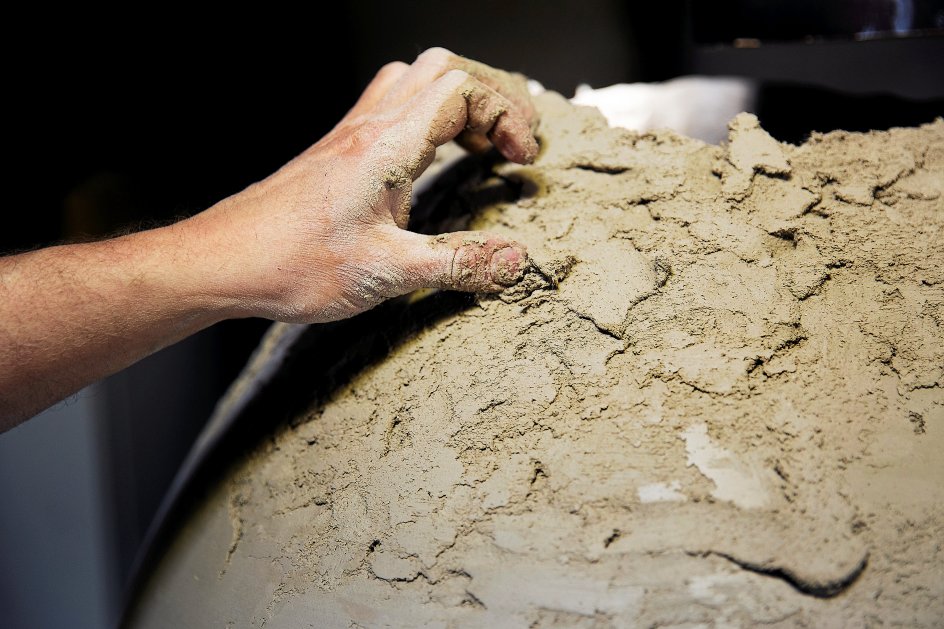 En kæmpekrukke er ved at komme til live i hænderne på en medarbejder på keramikværkstedet. Leret er blandet op med vinylfibre for at få den helt rigtige holdbarhed efter brænding – lidt på samme måde, som man i gamle dage blandede hestemøg med ufordøjede plantefibre i, fortæller Esben Lyngsaa Madsen. – Fotos: Carsten Bundgaard/Ritzau Scanpix.