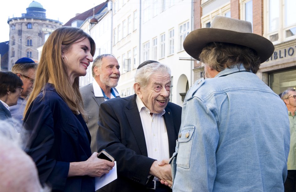 Tidligere overrabiner Bent Melchior og Henriette Harris fra den danske snublestensgruppe hilser på den tyske kunstner Gunter Demnig.