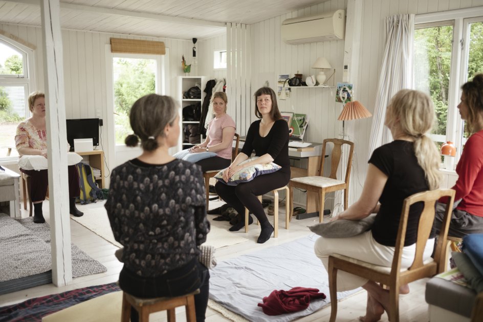 I sit haveforeningshus i Herlev underviser søvnkonsulent og leder af Søvnskolen Birgitte Hinz (med ryggen til nærmest kameraet) en gruppe kvinder i såkaldte mikrobevægelser. Små bevægelser, der skal berolige nervesystemet og gøre det nemmere at finde hvile og falde i søvn. Som mange andre danskere oplever de, at det kan være vanskeligt at finde roen i en hektisk hverdag. – Fotos: Asbjørn Sand.
