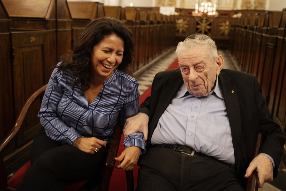 Der er altid masser af grin, når Bent Melchior og Özlem Cekic mødes. Som tidligere overrabbiner føler Bent Melchior sig hjemme i salen i Københavns Synagoge, hvor billedet her er taget, men de to har også begge et respektfuldt forhold til salen, hvor mindehøjtideligheden for Dan Uzan foregik for fem år siden. – Foto: Mikkel Møller Jørgensen.