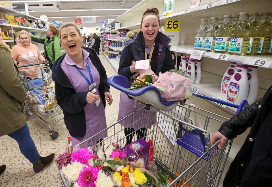 Sundhedspersonalet i det nationale britiske sundhedsvæsen NHS fik i denne uge foræret blomster som tak for deres store indsats, og det fik store smil frem hos disse sygeplejersker i Tesco-supermarkedet i Newcastle-under-Lyme. – Foto: Carl Recine/Ritzau Scanpix.