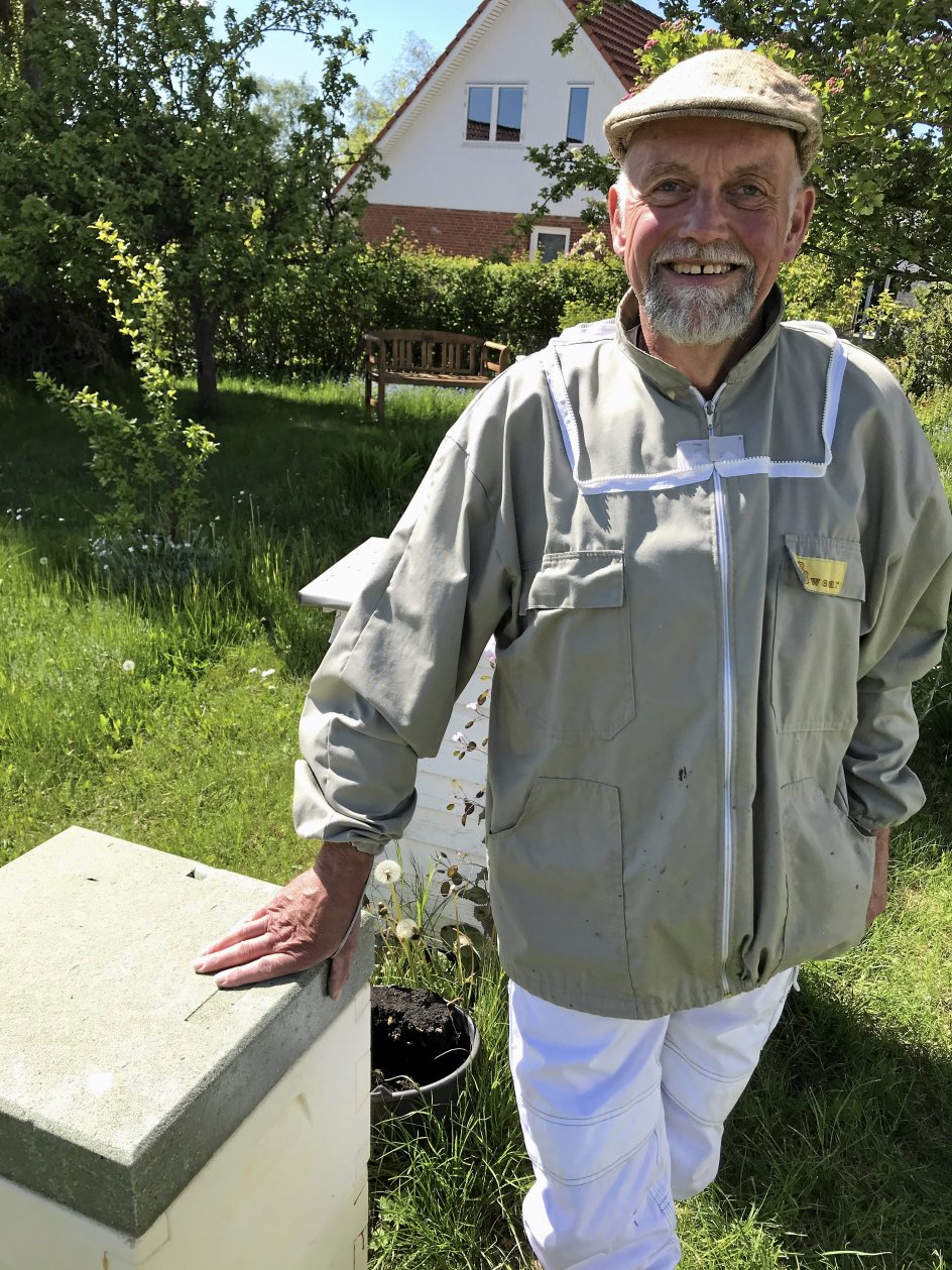 Hans-Erik Germuth ved sine bistader i haven i Roskilde. Han bor i et helt almindeligt villakvarter, og bierne har, ifølge ham selv, aldrig generet naboerne. – Foto: Lise Kabell Søgaard.