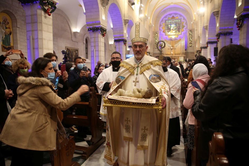 Pierbattista Pizzaballa, der er katolsk patriark i Jerusalem, bærer på en figur af Jesusbarnet under en julegudstjeneste i Fødselskirken i Betlehem. Og det er ikke en hvilken som helst kirke: Fødselskirken er eftersigende bygget på det sted, hvor Maria fødte Jesus.