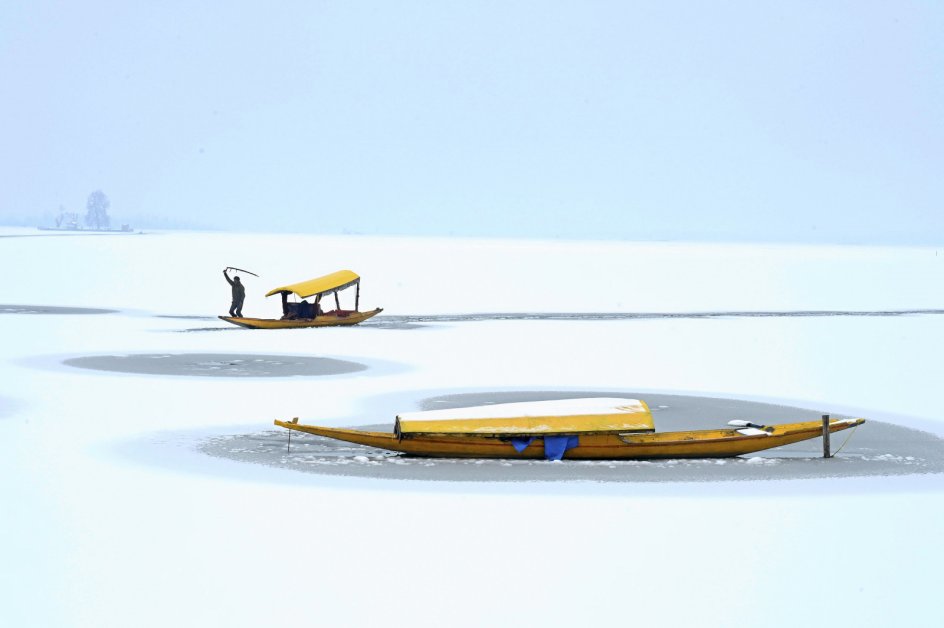 Om sommeren udgør byen Srinagar, hvor billedet er taget, hovedstaden i Indiens nordligste delstat, Jammu og Kashmir. På denne tid af året er det dog langt fra sommer, og lokale bådmænd har fået til opgave at navigere i den delvist frosne sø. Foto: Tauseef Mustafa/AFP/Ritzau Scanpix.