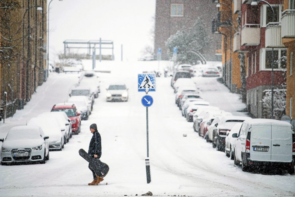 "Snö” siger vores naboer mod øst om de hvide fnug, der ikke så sjældent daler fra himlen hos dem. Her krydser en mand gaden i Sundbyberg nær Stockholm, mens en snestorm i sidste uge var i gang. – Foto: Jonathan Nackstrand/AFP/Ritzau Scanpix.