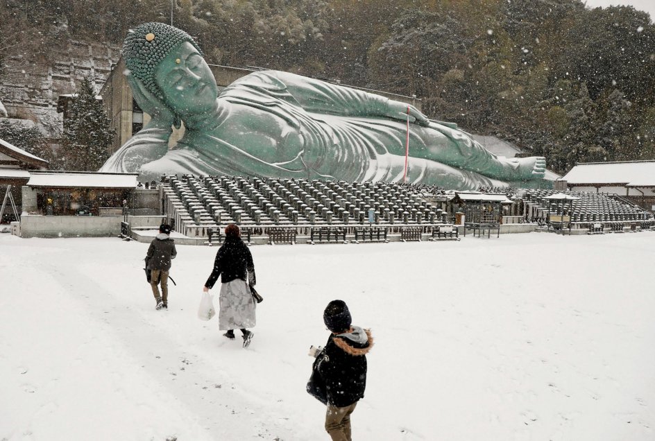 Foran det buddhistiske tempel Nanzoin, der ligger i den japanske by Sasaguri, er den liggende Buddha-statue blevet beklædt med et snetæppe. Med en længde på 41 meter og en vægt på knap 300 tons siges den at være verdens største bronzestatue. – Foto: AFP/Ritzau Scanpix.