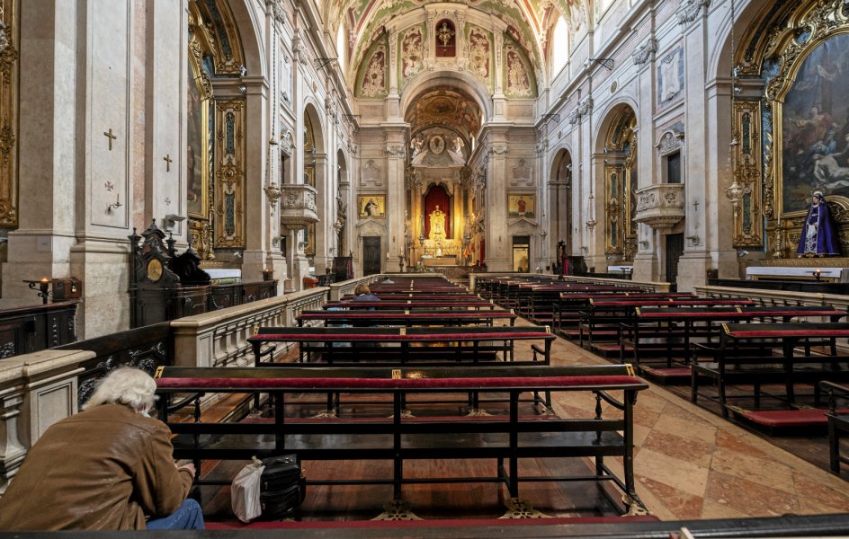 Da Portugal første gang lukkede ned for et år siden, fortsatte kirkelivet hurtigt online, men Francisco Motas kirke, Igreja de Nossa Senhora da Encarnação, in Praça Camoes, var fortsat åben, så enkelte kunne komme forbi og bede som her i slutningen af april sidste år. – Foto: Horacio Villalobos/Corbis via Getty Images.