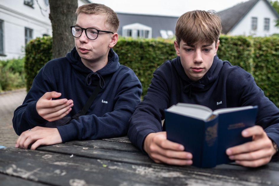 Luca Rosenborg (tv) og Daniel Frost (th) har ikke sunget fællessang hjemmefra og skulle lige i gang med det. Men nu synes de, det er noget, der giver energi.