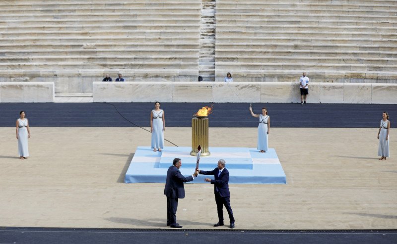 Formanden for den græske olympiske komite, Spyros Capralos, overdrog tirsdag den olympiske fakkel til den kinesiske næstformand for IOC og Beijings OL-organisationskomite, Yu Zaiqing, på Panathinaiko Stadion i Athen.