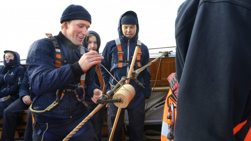 En håndfuld elever stimler sammen og følger koncentreret med, da en kammerat skal udskifte et bramskøde. Selv når de ikke selv er på vagt, er de fleste af eleverne nysgerrige på, hvad der foregår rundt omkring på skibet.