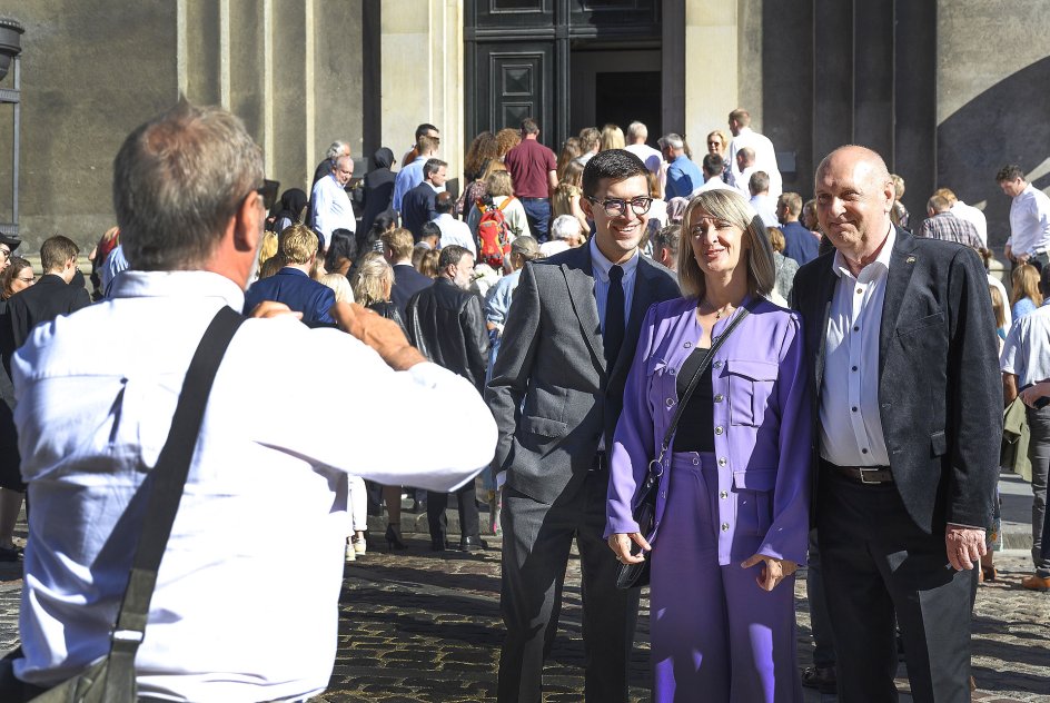 På vej ind til ceremonien i festsalen i Københavns Universitets hovedbygning lader Moisès Alberto Suaez Zdunek sig fotografere af en bekendt sammen med sin mor og sin stedfar.