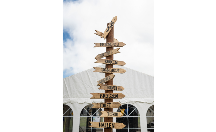 En vejviser på festivalspladsen guider til både toiletter, missionshuset - og Himlen.