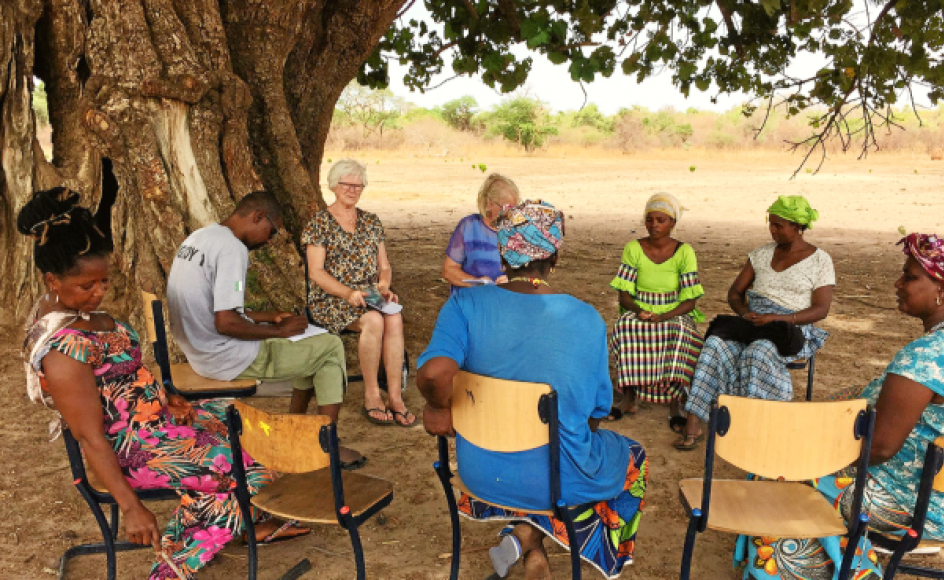Thea Lauridsen og Ruth Noer holder, med hjælp fra en tolk, møde med en kvindegruppe i en landsby i Gambia. De to danskere ved godt, at det frivillige arbejde kan synes som en dråbe i havet, men vi ”kan være med til at ændre og udvikle noget, der hjælper nogle afrikanske landsbybeboere ud af fattigdom, dårlig hygiejne og analfabetisme, og som blandt andet kan gøre, at unge bliver i deres hjemland – i stedet for at tage over Middelhavet, hvor vi efterhånden ved, hvor det ender,” fortæller de.