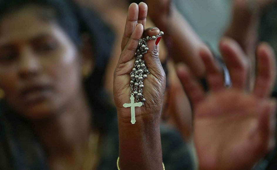 En demonstrant hæver et kors i menneskemængden under en protest mod angreb på kristne kirker i Mumbai i Indien i 2015. Indien er på listen over lande, hvor den værste form for brud på religionsfriheden finder sted.