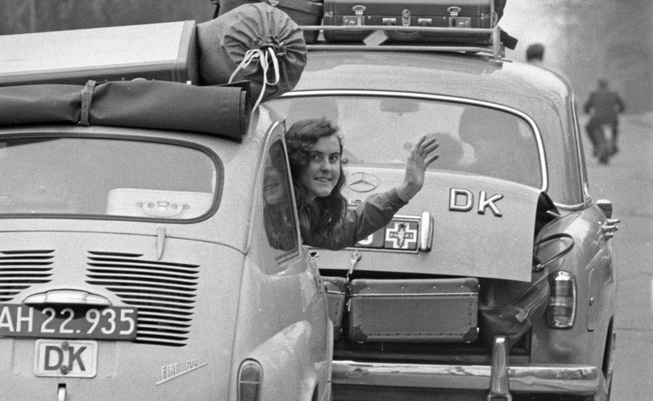 Bilferie blev for alvor populært i 1960’erne, da flere danskere fik råd til at købe en bil. Her vinker en kvinde på vej på bilferie i 1959 til fotografen.
