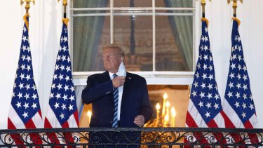 Donald Trump tog sit mundbind af, da han stillede op til billeder, kort tid efter at han var kommet tilbage til Det Hvide Hus.