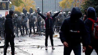 Demonstranter foran en mur af politibetjente i Bruxelles ved en af weekendens mange demonstrationer mod corona-restriktioner.