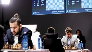 Det gamle skakspil er i dag blevet digitaliseret i et omfang, så den norske verdensmester Magnus Carlsen (til højre) i mange år ikke ejede et skakbræt eller et sæt brikker. Hans russiske modstander, Ian Nepomniachtchi, som ses med ansigtet til ved bordet til venstre, har været halvprofessionel inden for computerspillet Dota.
