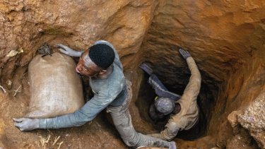 Congolesiske minearbejdere bakser med at hente sække med kobolt op fra undergrunden i Kolwezi i DR Congo.